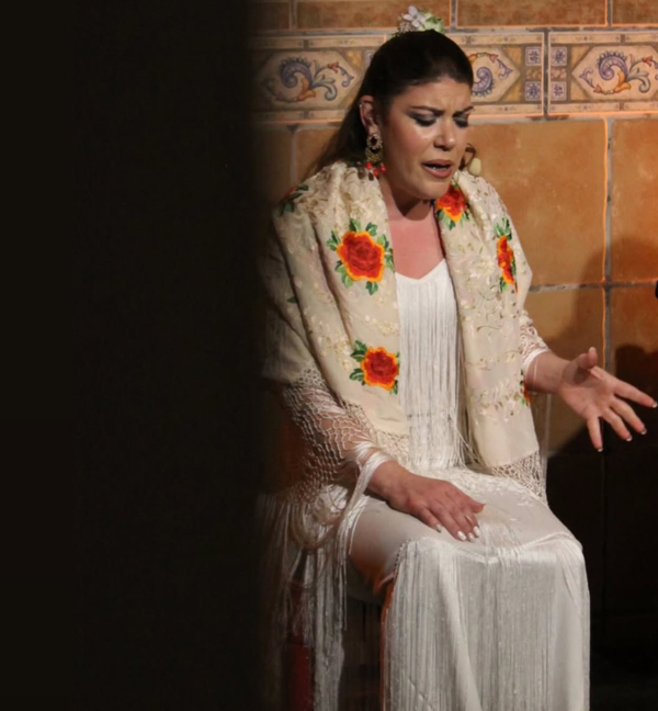 Foto de Fabiola Santiago sentada, cantando.